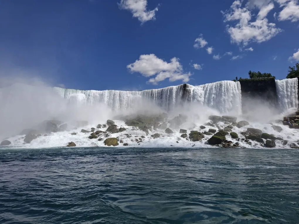 Waterfall cascading over rocks under a blue sky, from the Salmons family’s Youth Impact newsletter.